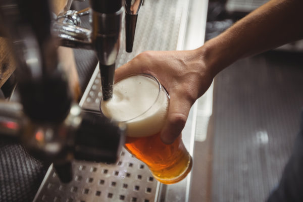 close-up-bar-tender-filling-beer-from-bar-pump